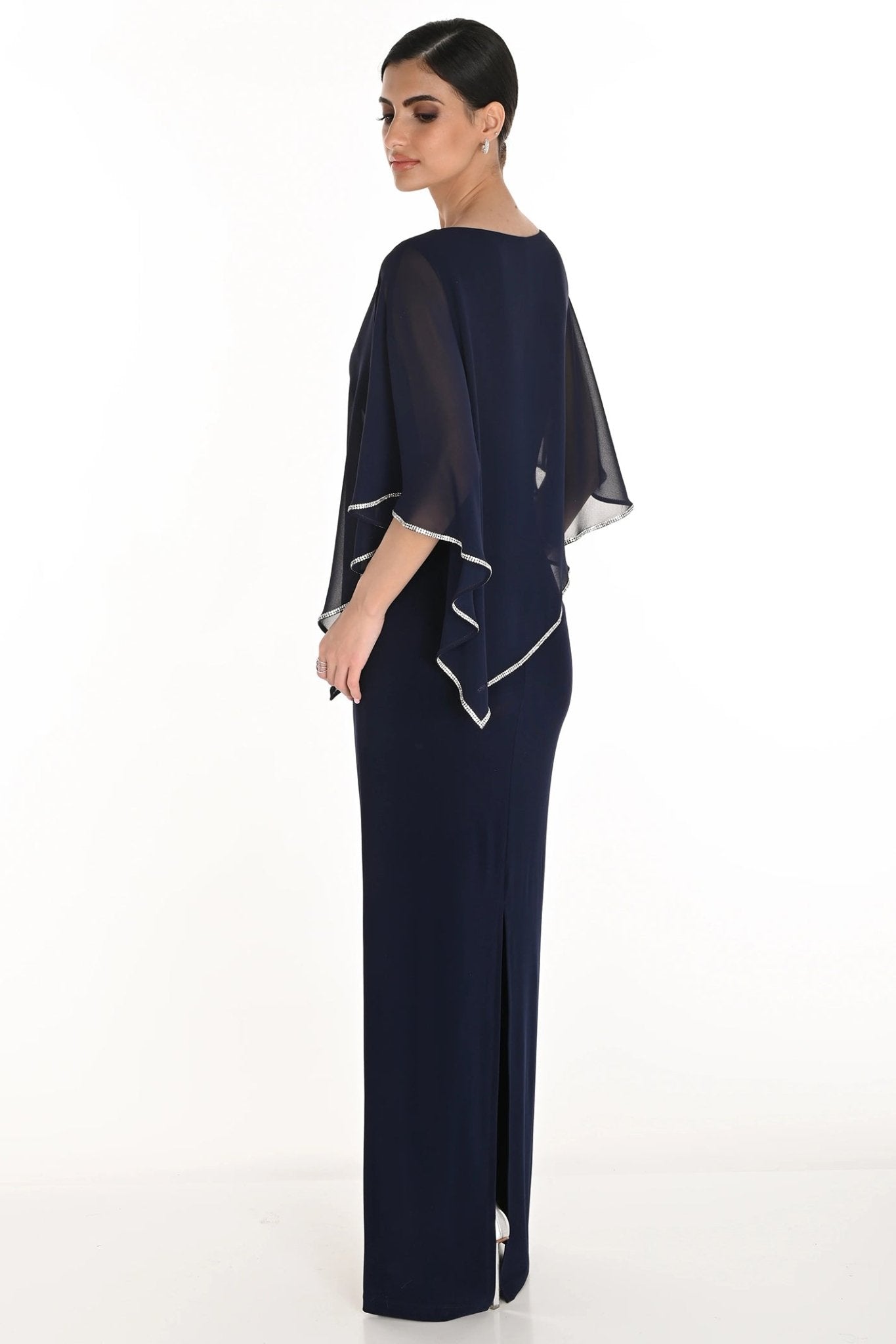 Woman wearing a navy blue dress with sheer sleeves on a white background