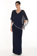 Woman wearing a navy blue evening gown with a sheer white overlay on a white background