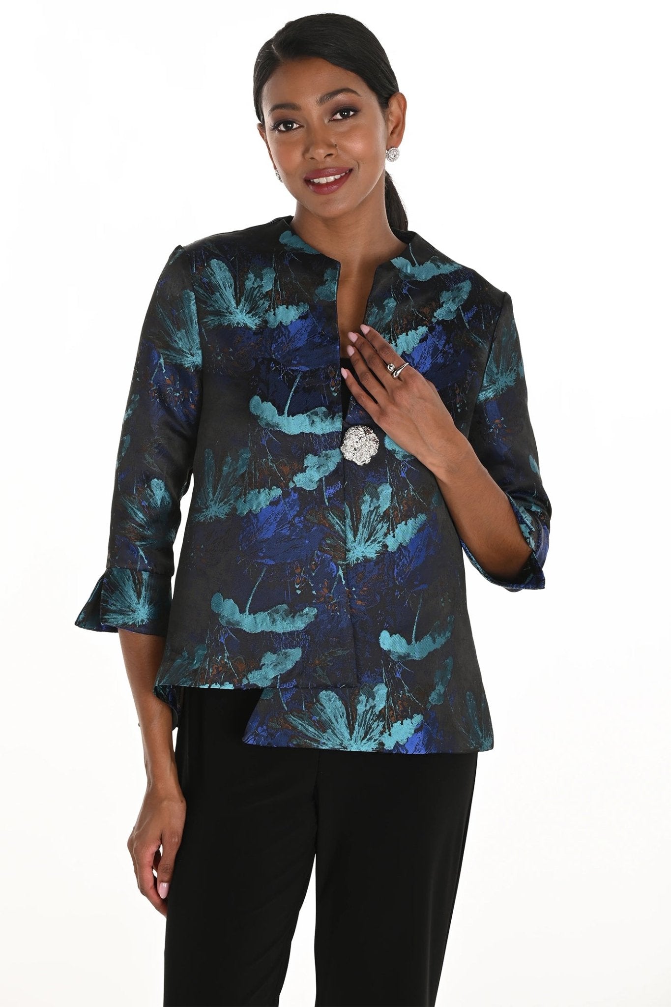 Woman wearing a dark floral patterned blouse with a white background
