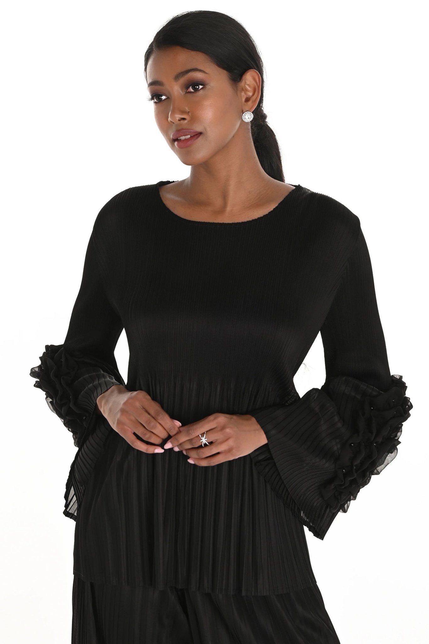Woman wearing a black dress with ruffled sleeves on a white background