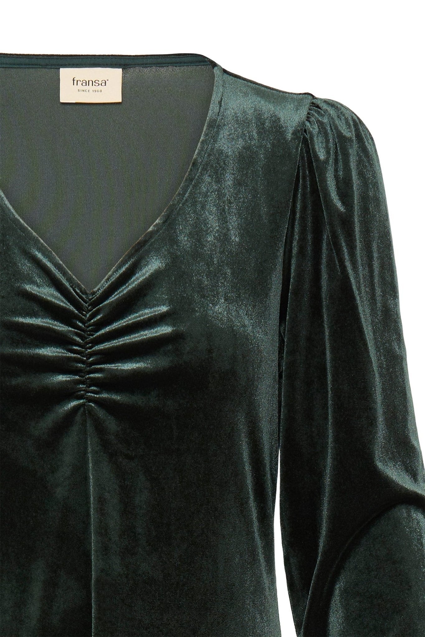 Green velvet dress with a label on a white background