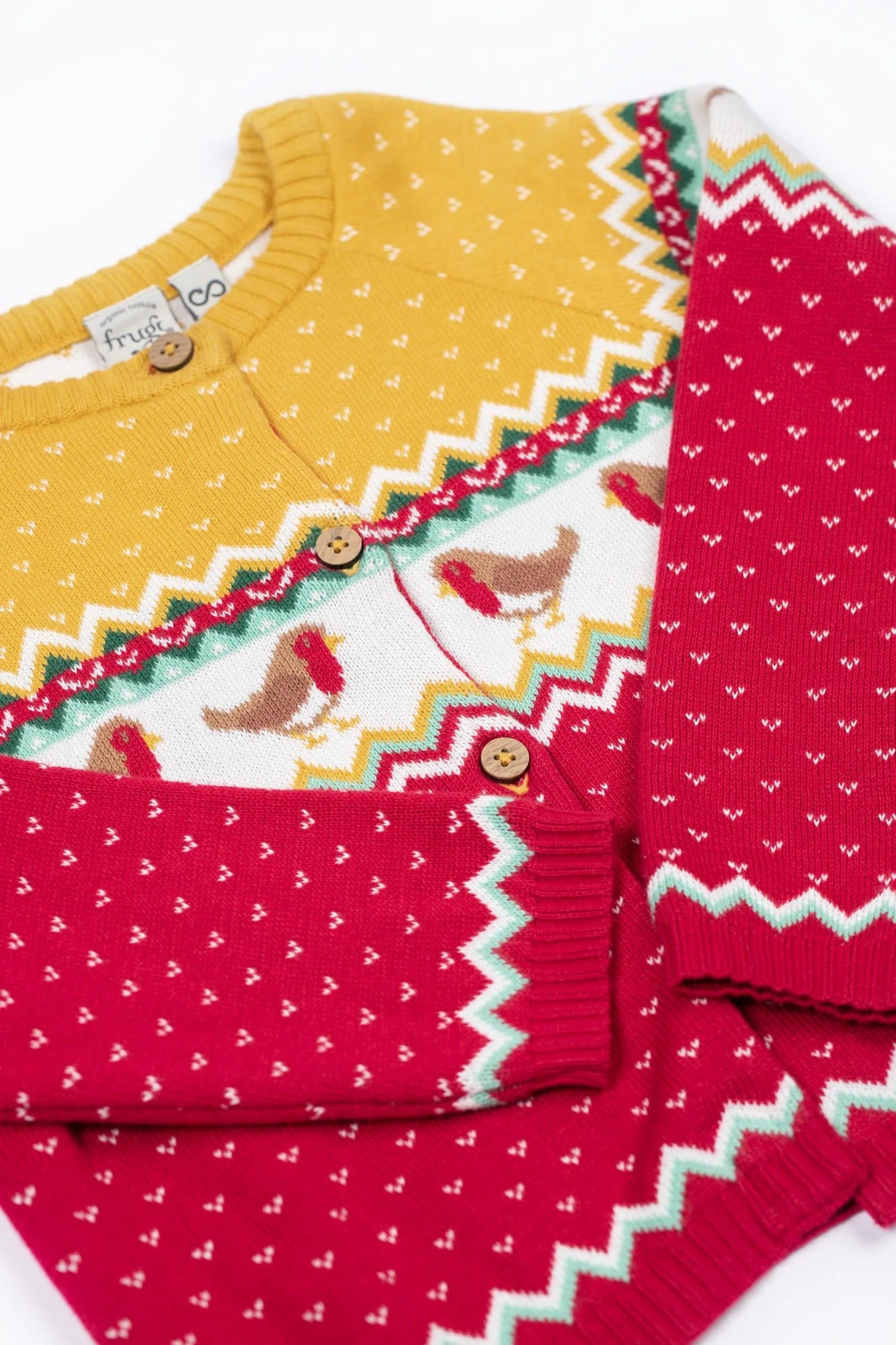 Two children's sweaters with different patterns on a white background