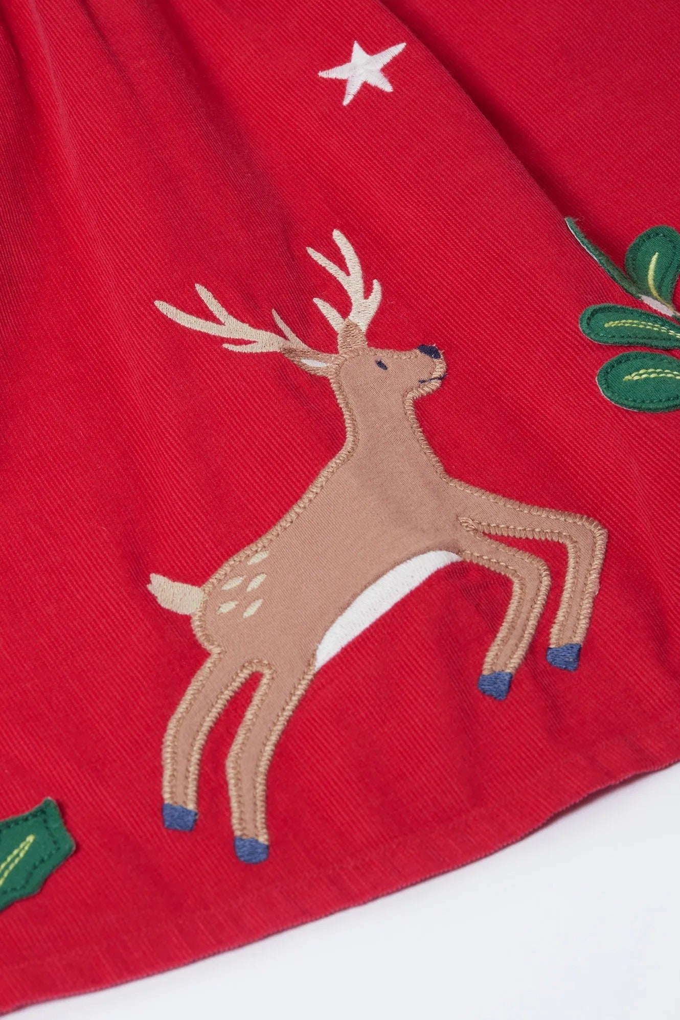 Embroidered reindeer on a red fabric background