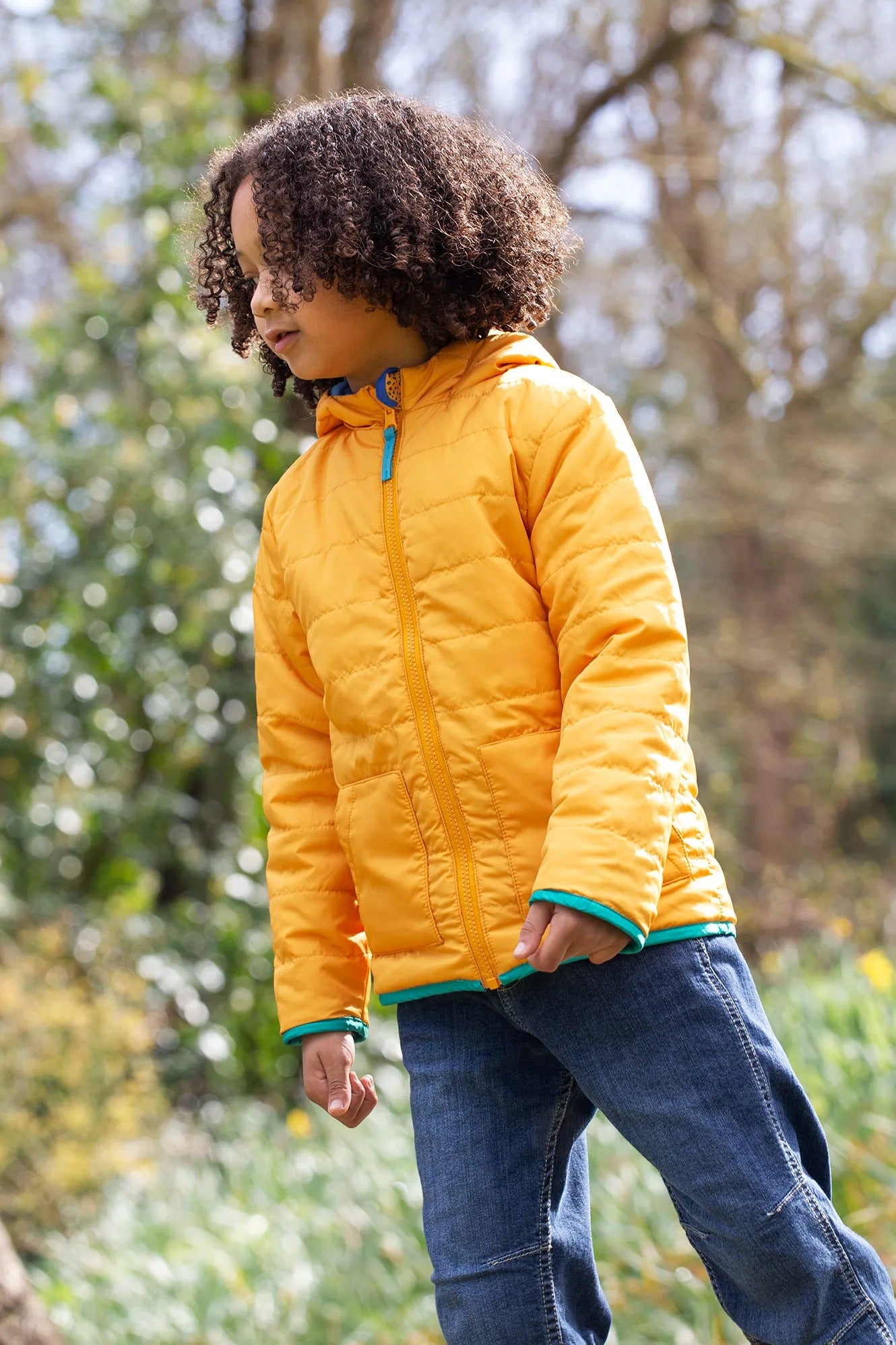 Child wearing a yellow puffer jacket in a natural setting