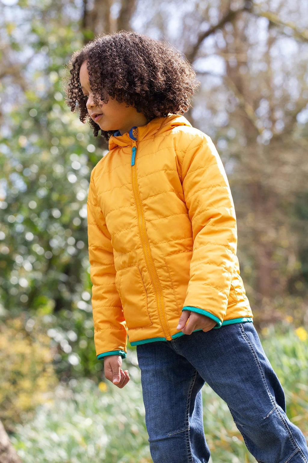 Child wearing a yellow puffer jacket in a natural setting
