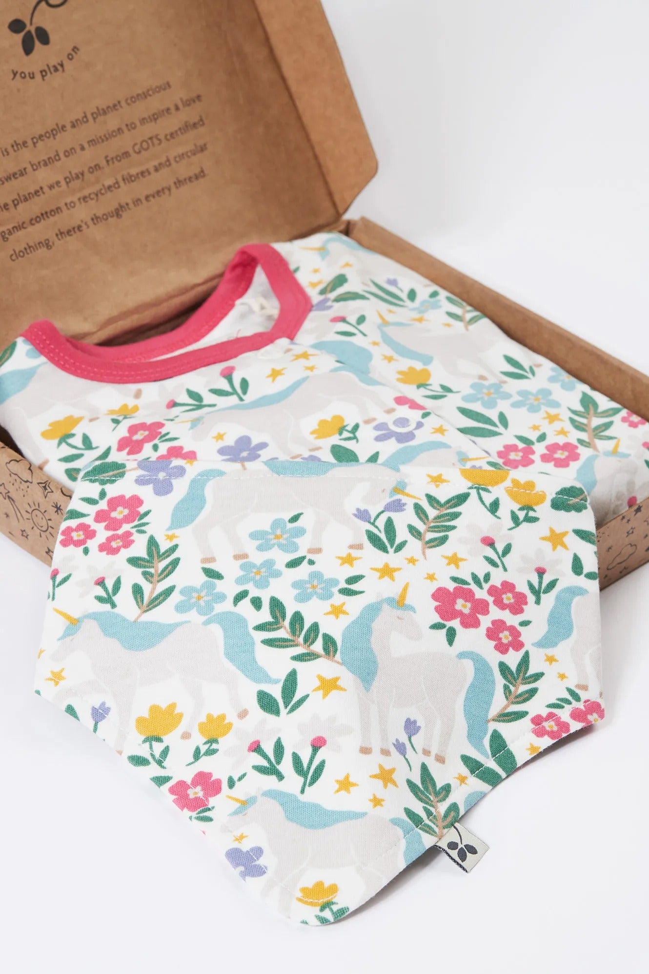 Baby onesie with floral and dinosaur pattern on a cardboard box