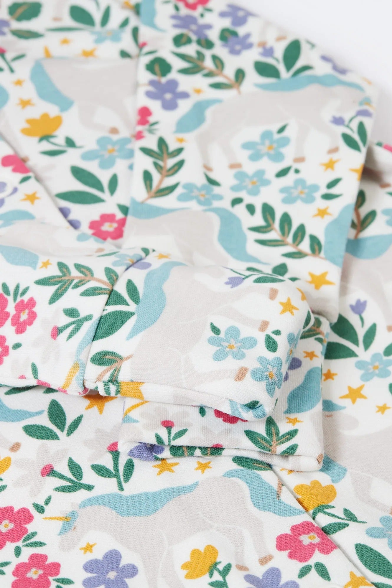 Floral patterned fabric with colorful flowers and leaves on a white background