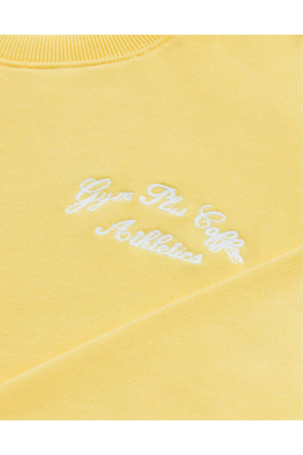 Close-up of embroidered logo on Gym+Coffee Urban Crewneck in Lemon Sorbet soft knit, shop Gym+Coffee at Dotique for casual layers