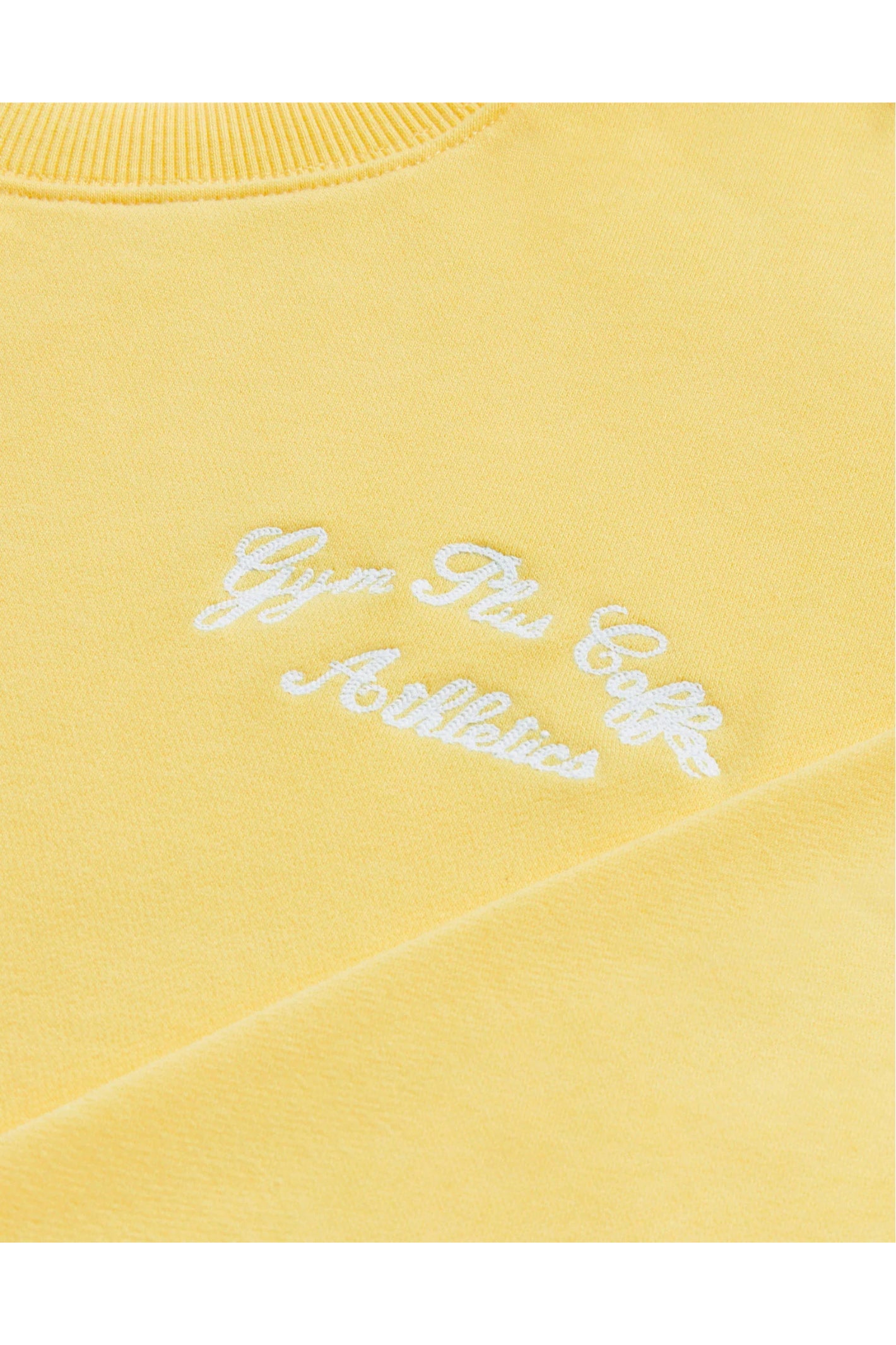 Close-up of embroidered logo on Gym+Coffee Urban Crewneck in Lemon Sorbet soft knit, shop Gym+Coffee at Dotique for casual layers