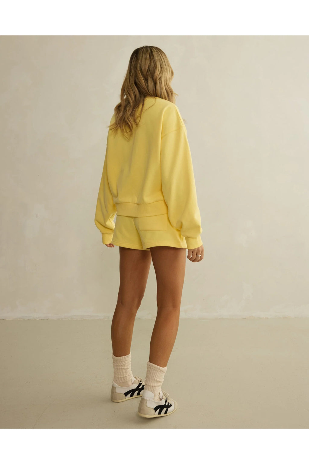 Rear view of model in Gym+Coffee Urban Crewneck in Lemon Sorbet soft knit, shop Gym+Coffee at Dotique for casual activewear layers