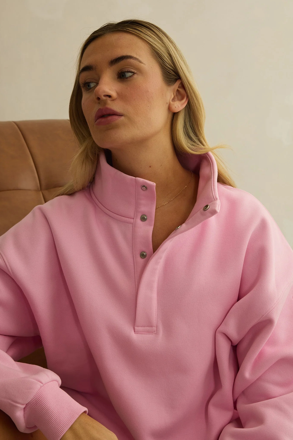 Woman seated wearing Gym+Coffee Snap Collar High Waist Sweatshirt Pink Blossom by gym+coffee, shop gym+coffee at Dotique
