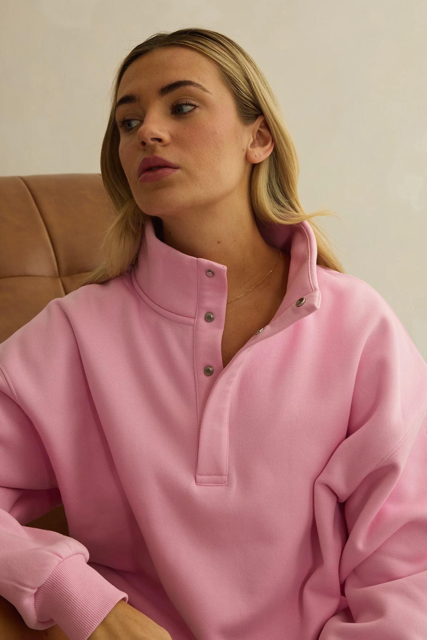 Woman seated wearing Gym+Coffee Snap Collar High Waist Sweatshirt Pink Blossom by gym+coffee, shop gym+coffee at Dotique