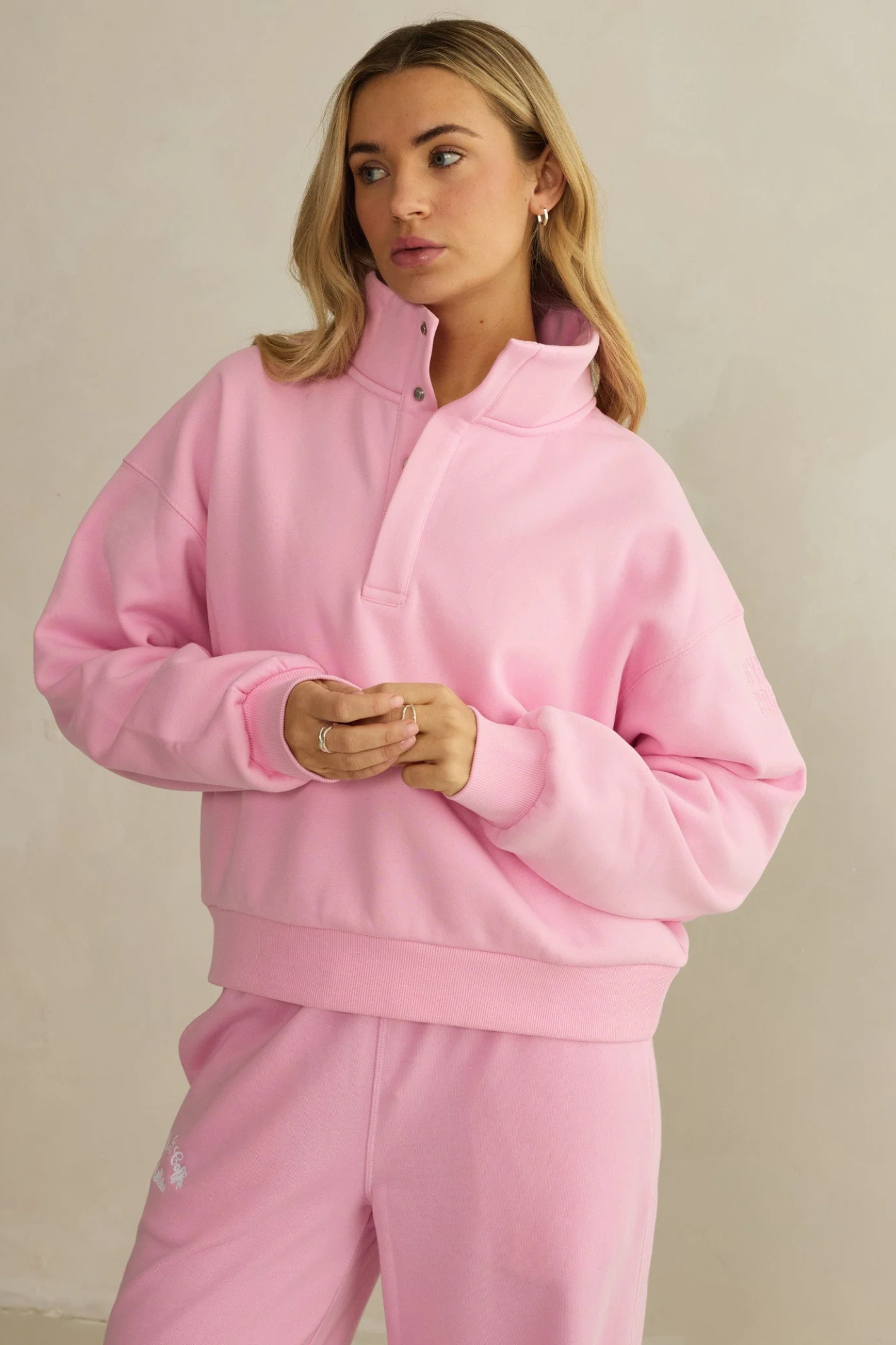 Model wearing Gym+Coffee Snap Collar High Waist Sweatshirt Pink Blossom by gym+coffee, shop gym+coffee at Dotique in soft pink tone