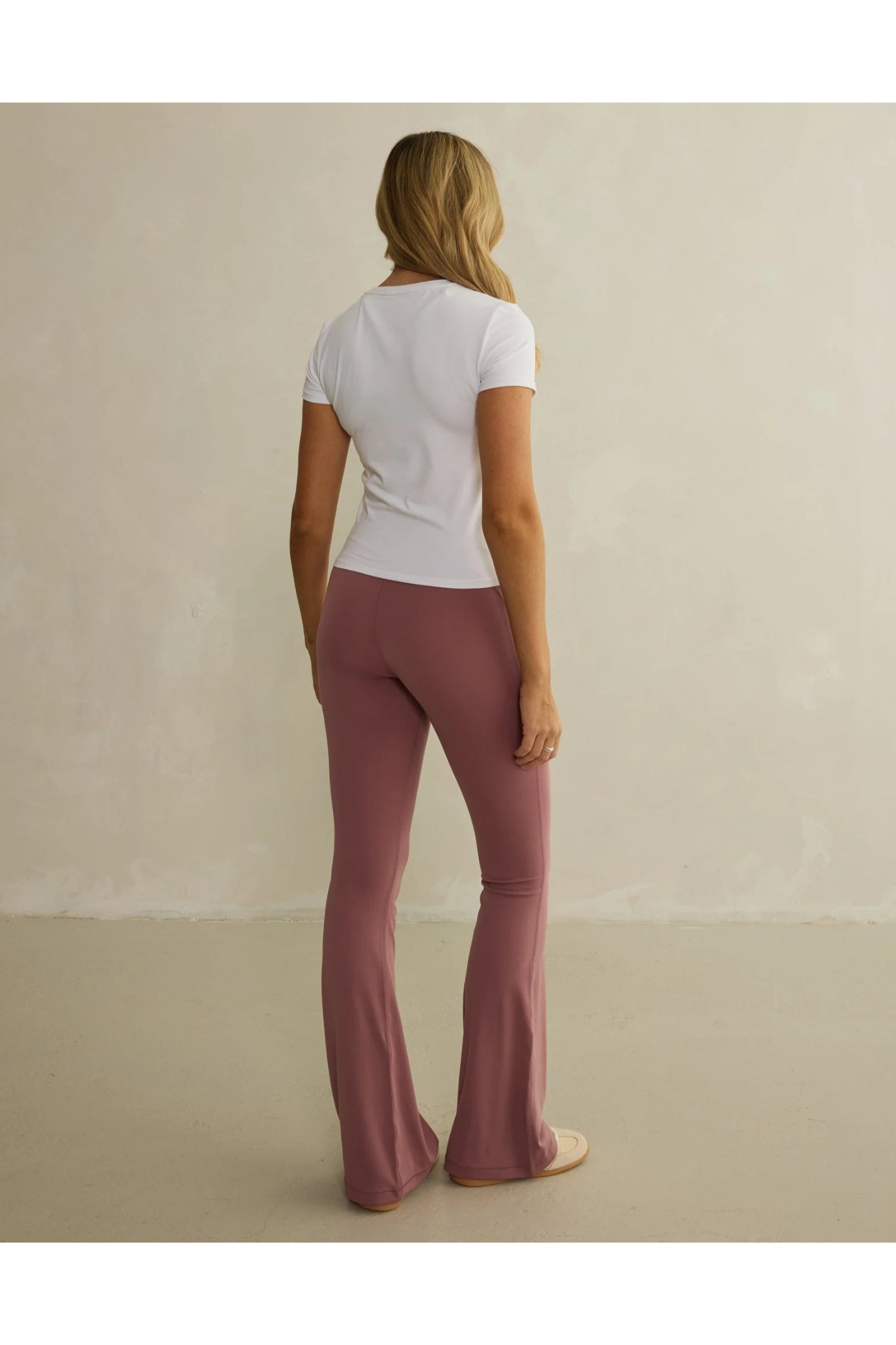 Rear view of model wearing Gym+Coffee Soft Motion Flares - Terra Rose flared leggings, shop Gym+Coffee at Dotique for versatile activewear