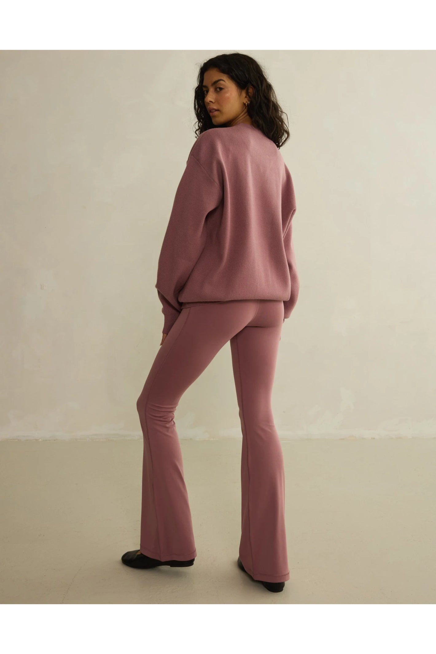 Model wearing Gym+Coffee Soft Motion Flares - Terra Rose flared leggings, shop Gym+Coffee at Dotique for stylish activewear