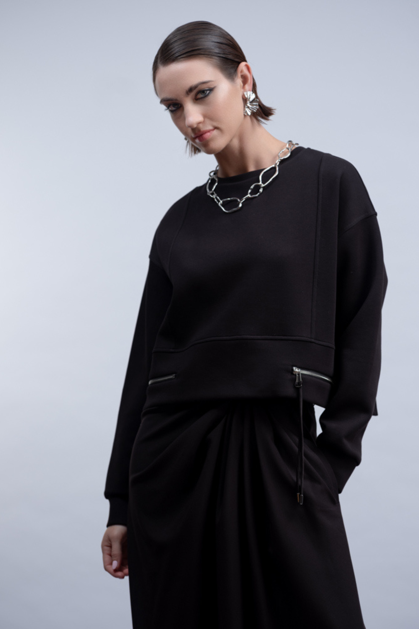 Shop the Haako H2024 black knit top with twin zip pocket detail at the hem. A relaxed crew neck sweat top for effortless everyday styling at Dotique.