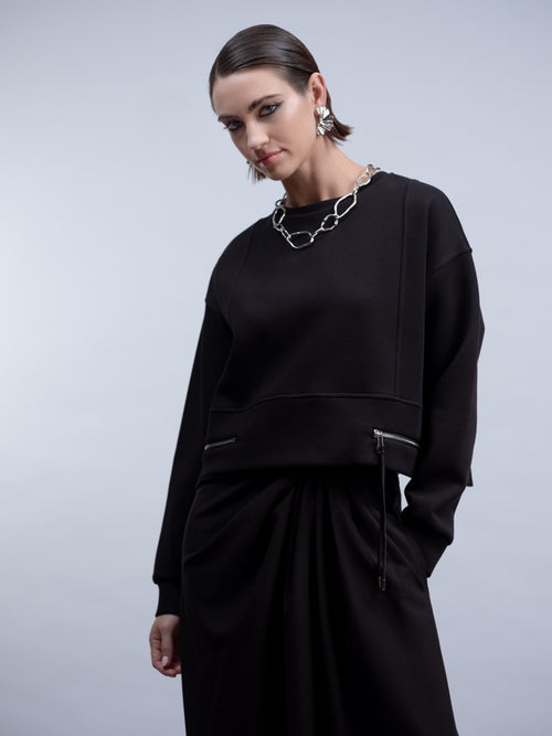 Shop the Haako H2024 black knit top with twin zip pocket detail at the hem. A relaxed crew neck sweat top for effortless everyday styling at Dotique.