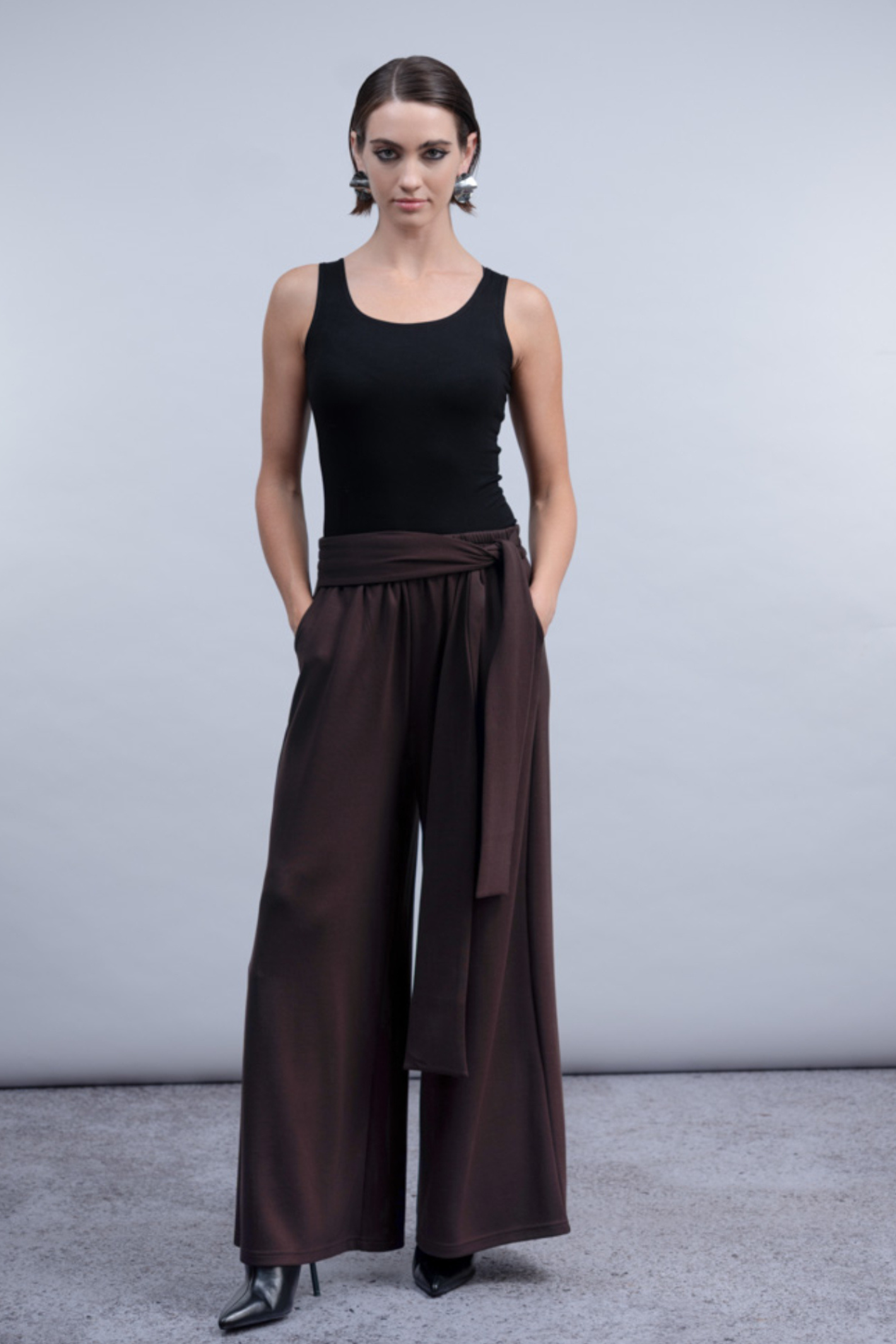 Shop the Haako H2030 wide-leg trousers in chocolate brown with a wrap-tie waist. Soft, flowing fabric for effortless everyday or occasion styling at Dotique.