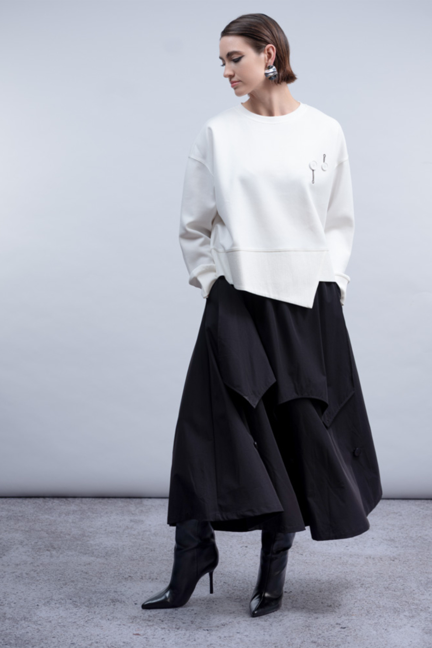Shop the Haako H2046 white sweat top with quirky button and safety pin embroidered detail. An oversized crew neck top with asymmetric hem at Dotique.