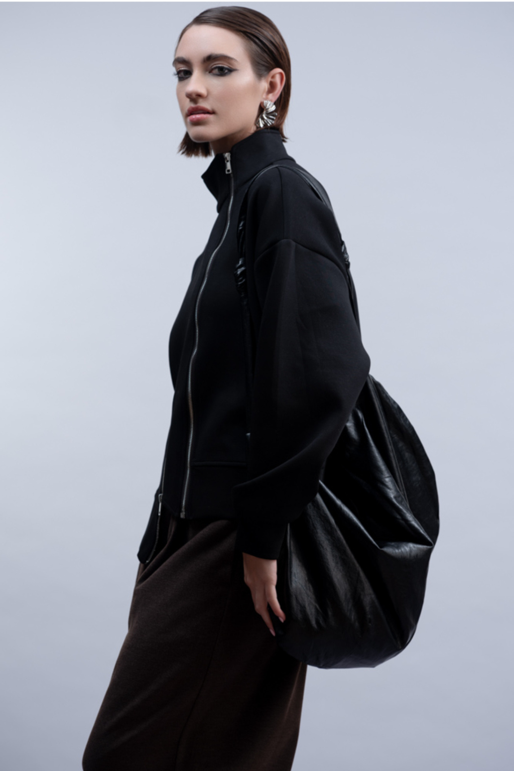 Shop the Haako H2048 black sweat jacket with asymmetric zip and stand collar. An oversized, sporty-luxe layering piece at Dotique.