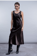 Shop the Haako H2059 brown satin slip dress with scoop neck and asymmetric hem detail. A sleek, elevated midi dress at Dotique.