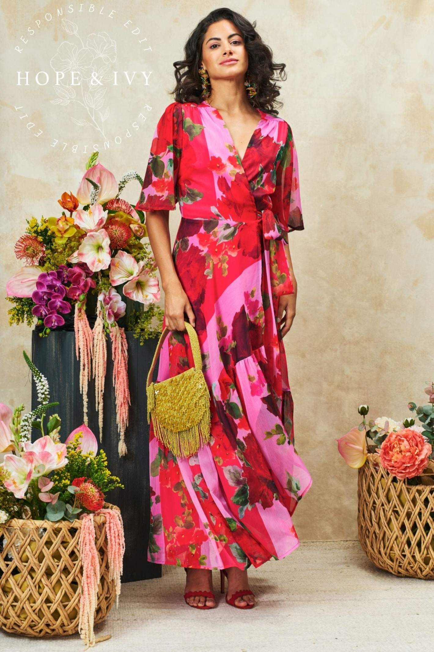 Flattering wrap maxi dress by Hope & Ivy in a pink and red floral print. Flutter sleeves, tie waist and flowing skirt. Shop Hope & Ivy Dresses at Dotique.