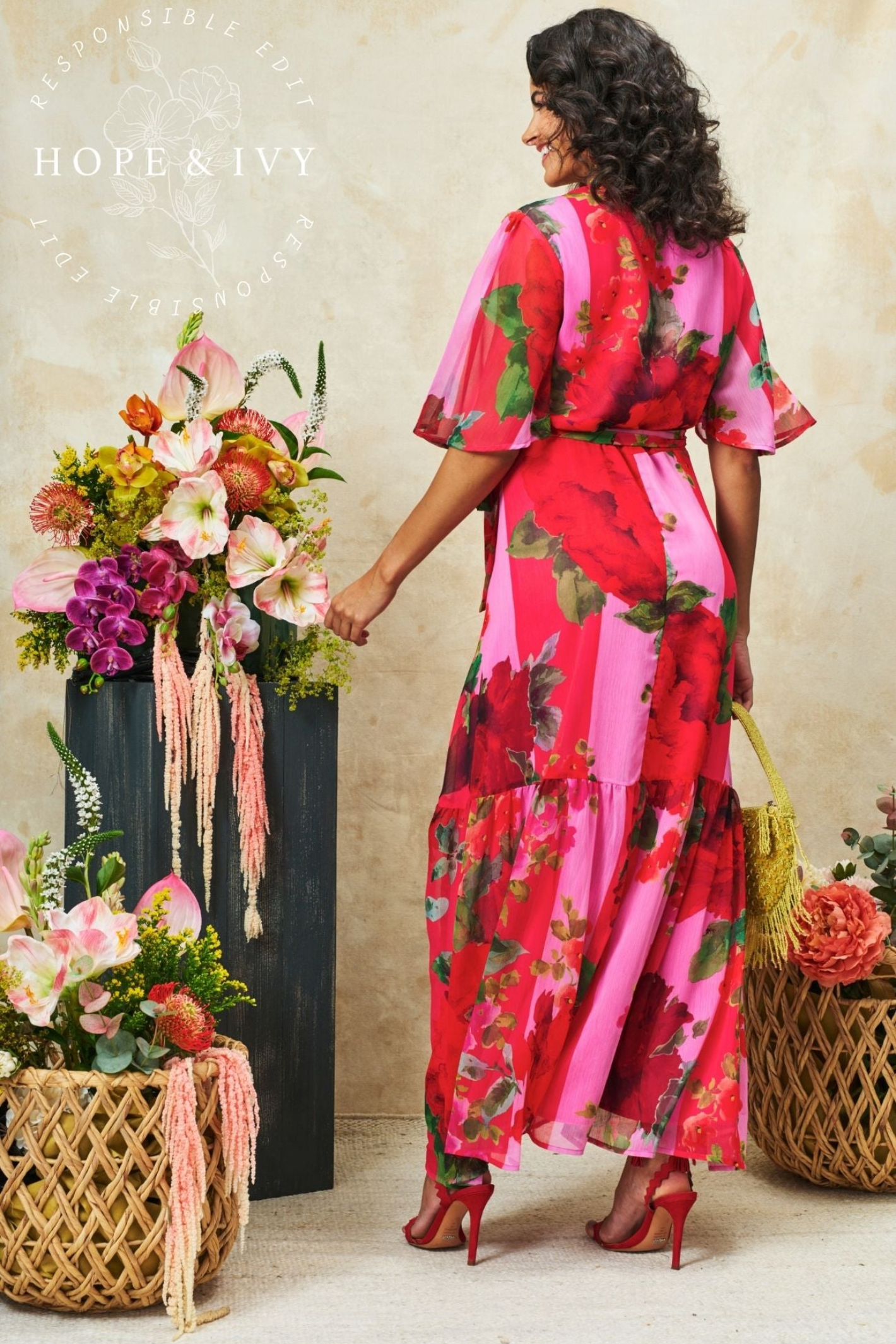 Flattering wrap maxi dress by Hope & Ivy in a pink and red floral print. Flutter sleeves, tie waist and flowing skirt. Shop Hope & Ivy Dresses at Dotique.