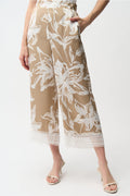 Model wearing Joseph Ribkoff 261023 Recycled Satin Floral Print Pull-On Culotte Pants in beige with white floral design and lace hem by Joseph Ribkoff, shop Joseph Ribkoff at Dotique.