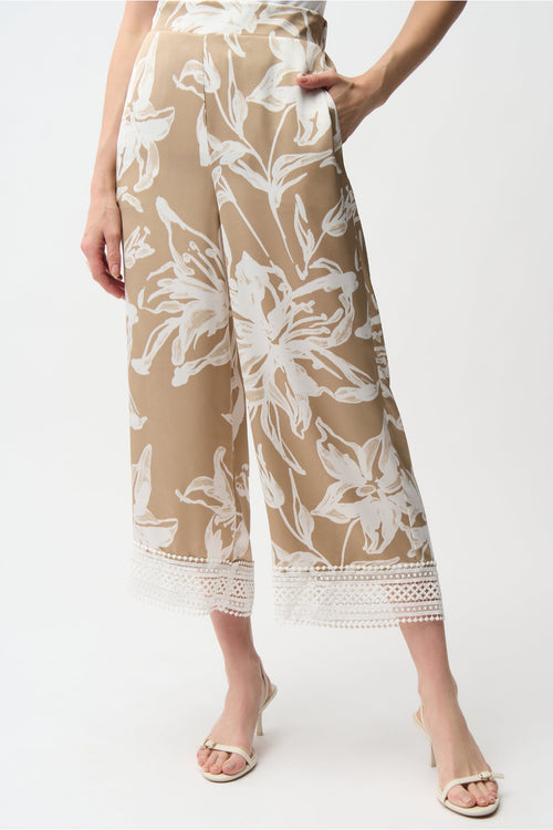 Model wearing Joseph Ribkoff 261023 Recycled Satin Floral Print Pull-On Culotte Pants in beige with white floral design and lace hem by Joseph Ribkoff, shop Joseph Ribkoff at Dotique.