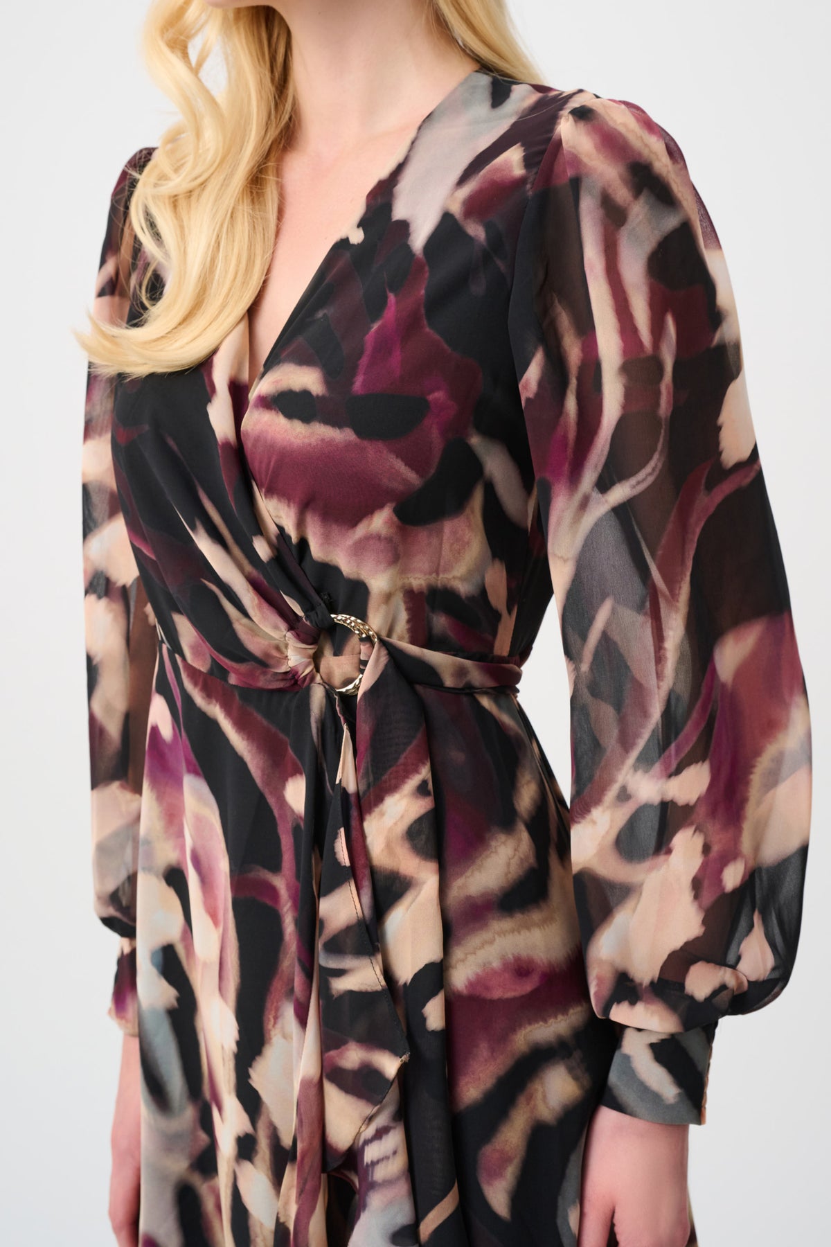 Woman wearing a long sleeve abstract print dress with a gathered waist