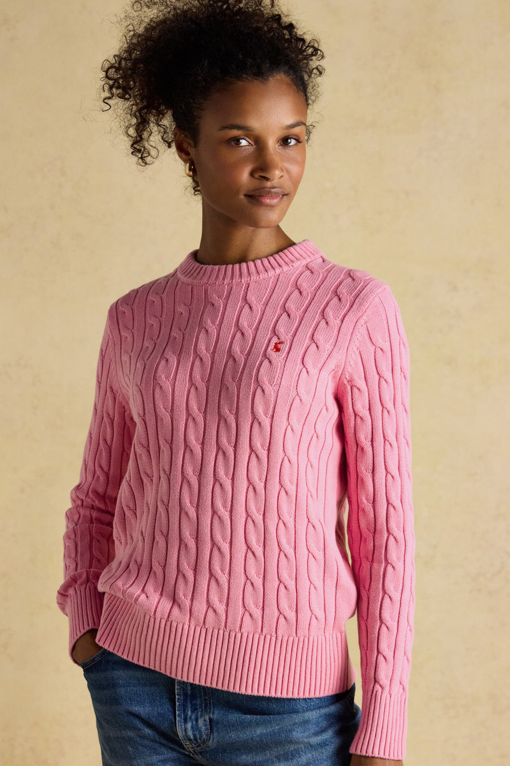Shop the Joules Classic Cable Jumper in Pink at Dotique. A 100% cotton cable knit with a crew neck, ribbed trims and signature Joules hare embroidery.