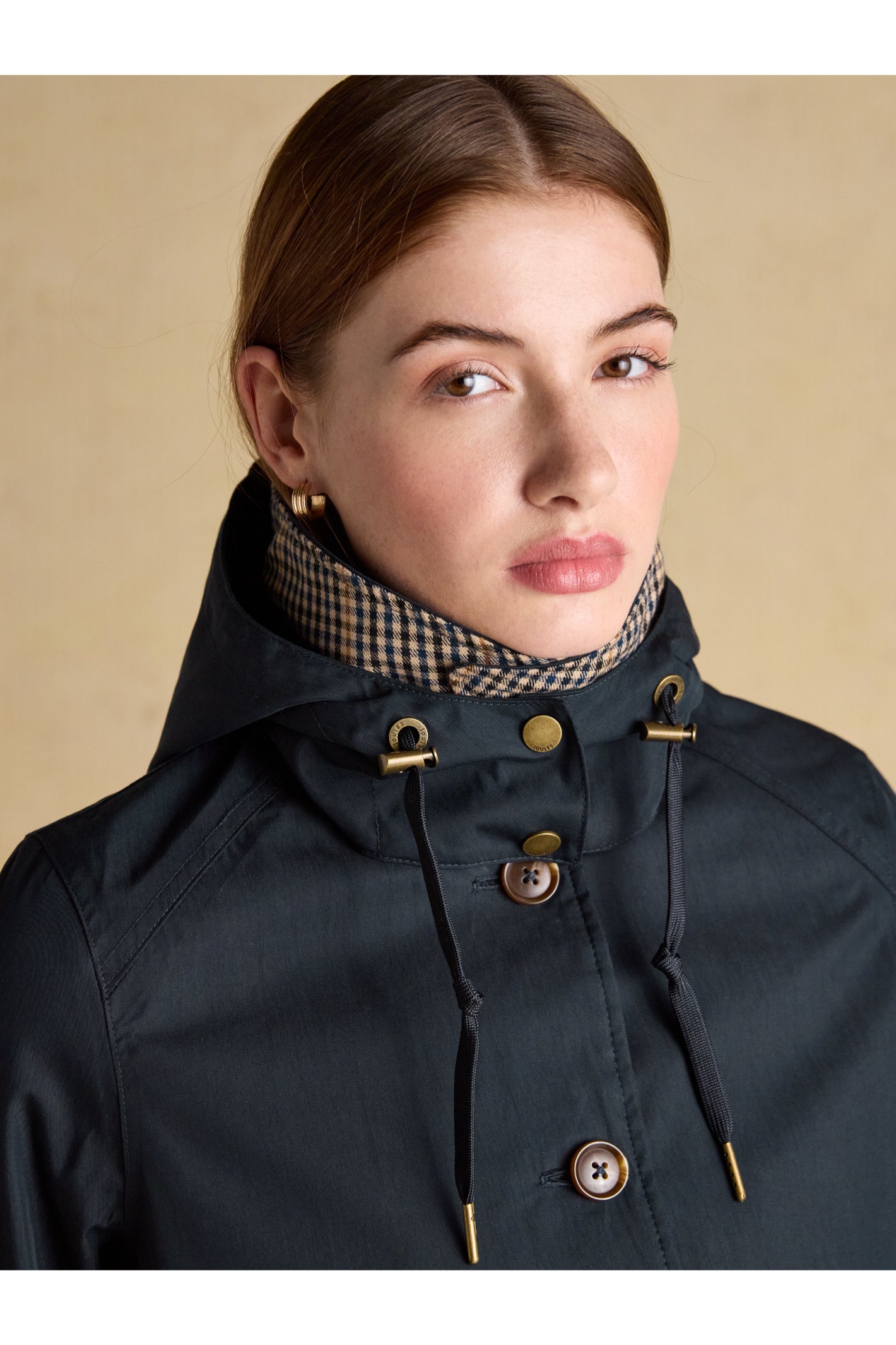 Close-up of a woman wearing Joules H23721 Rainmore Waterproof Coat – Navy by Joules, shop Joules at Dotique.