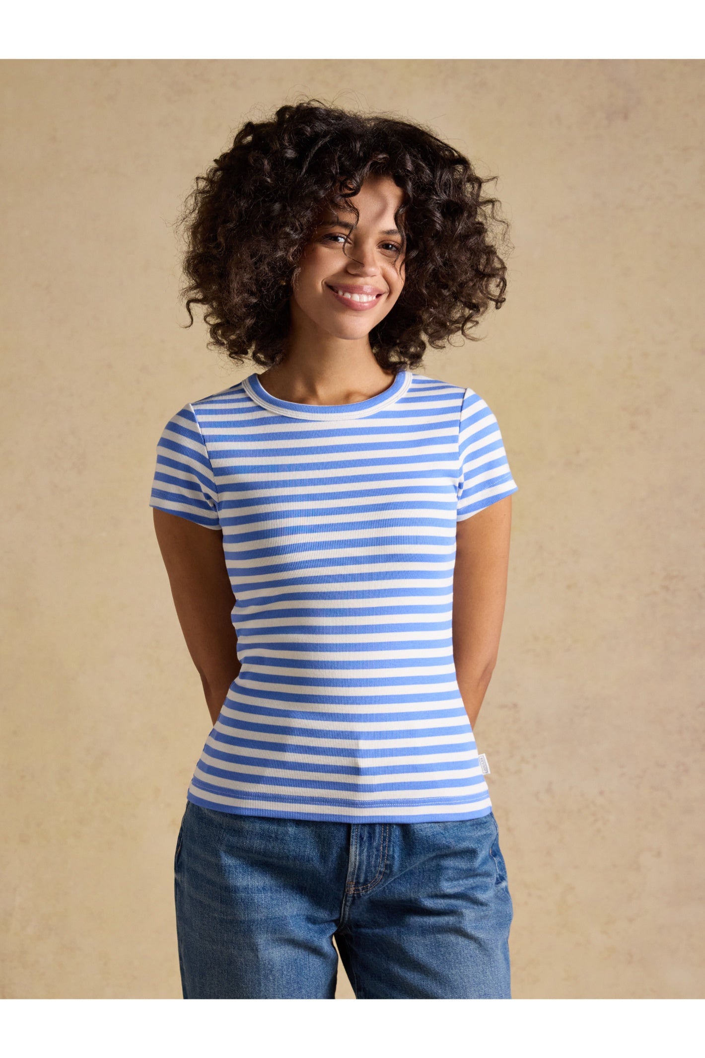 Woman wearing a blue and white striped Joules H77966 Sophie Ribbed T-Shirt – Blue Stripe, shop Joules at Dotique.