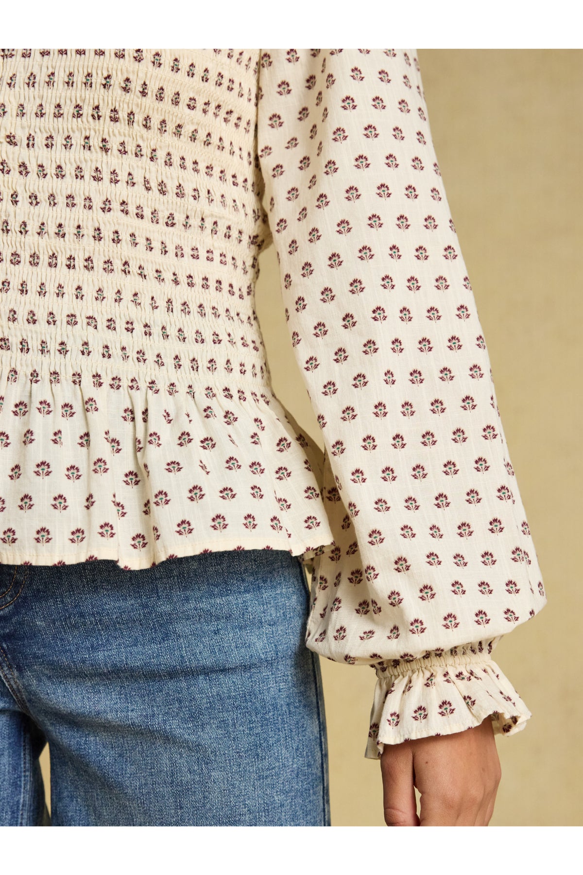 Shop the Joules Zoe Blouse in Cream Ditsy at Dotique. A 100% cotton blouse with a smocked bodice, frill collar, adjustable zip and long sleeves.