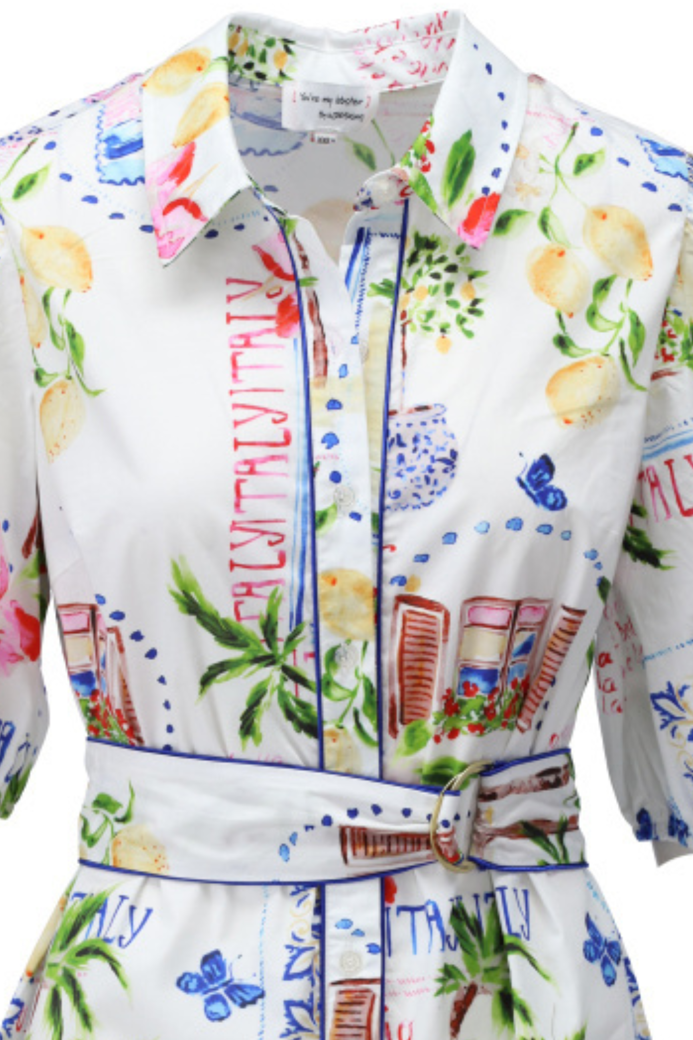 Close-up of white midi dress with colorful floral and lemon print, button-up front, collar, and matching belted waist