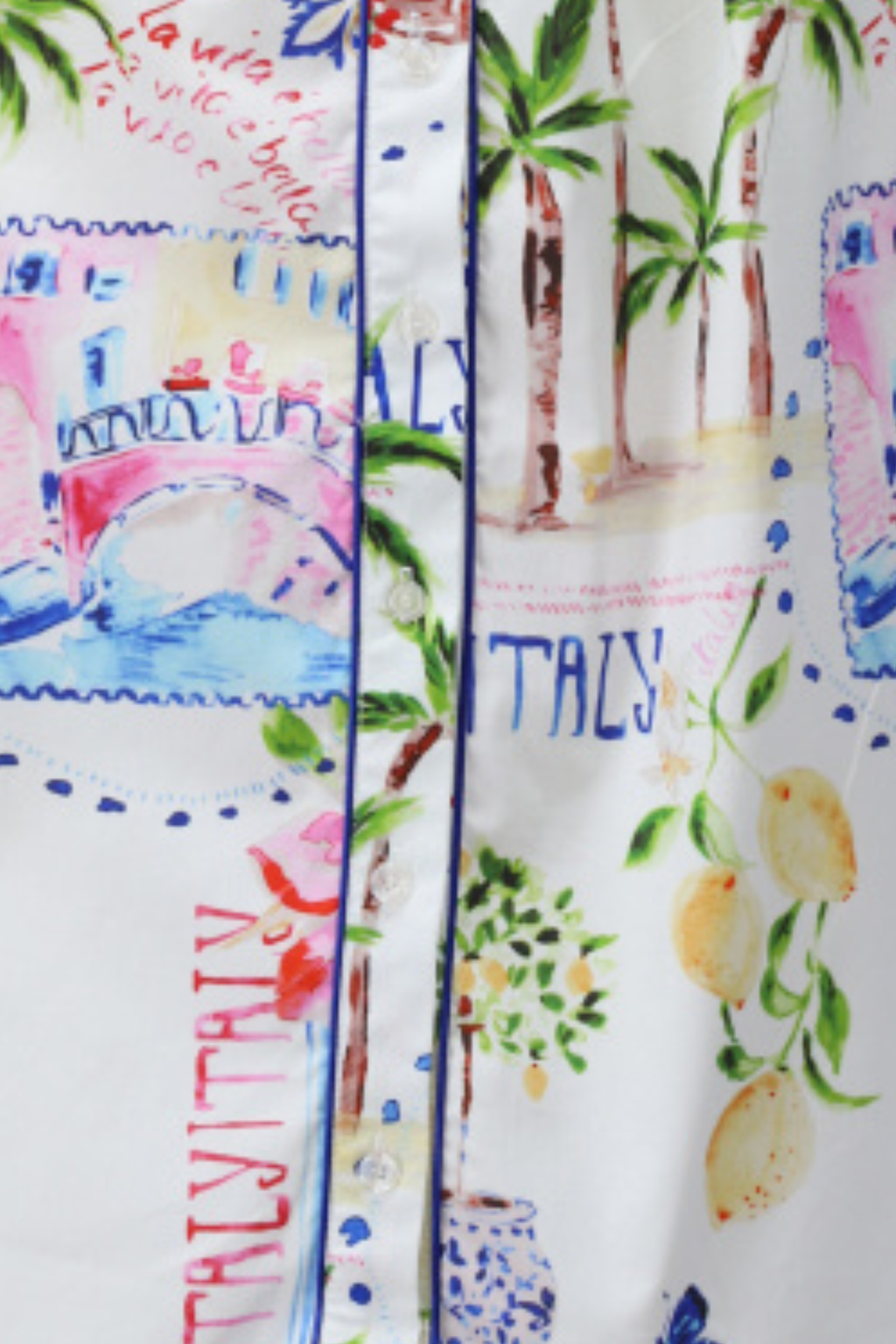 Close-up of white fabric with colorful Italy-themed print featuring lemons, palm trees, and scenic sketches near button placket