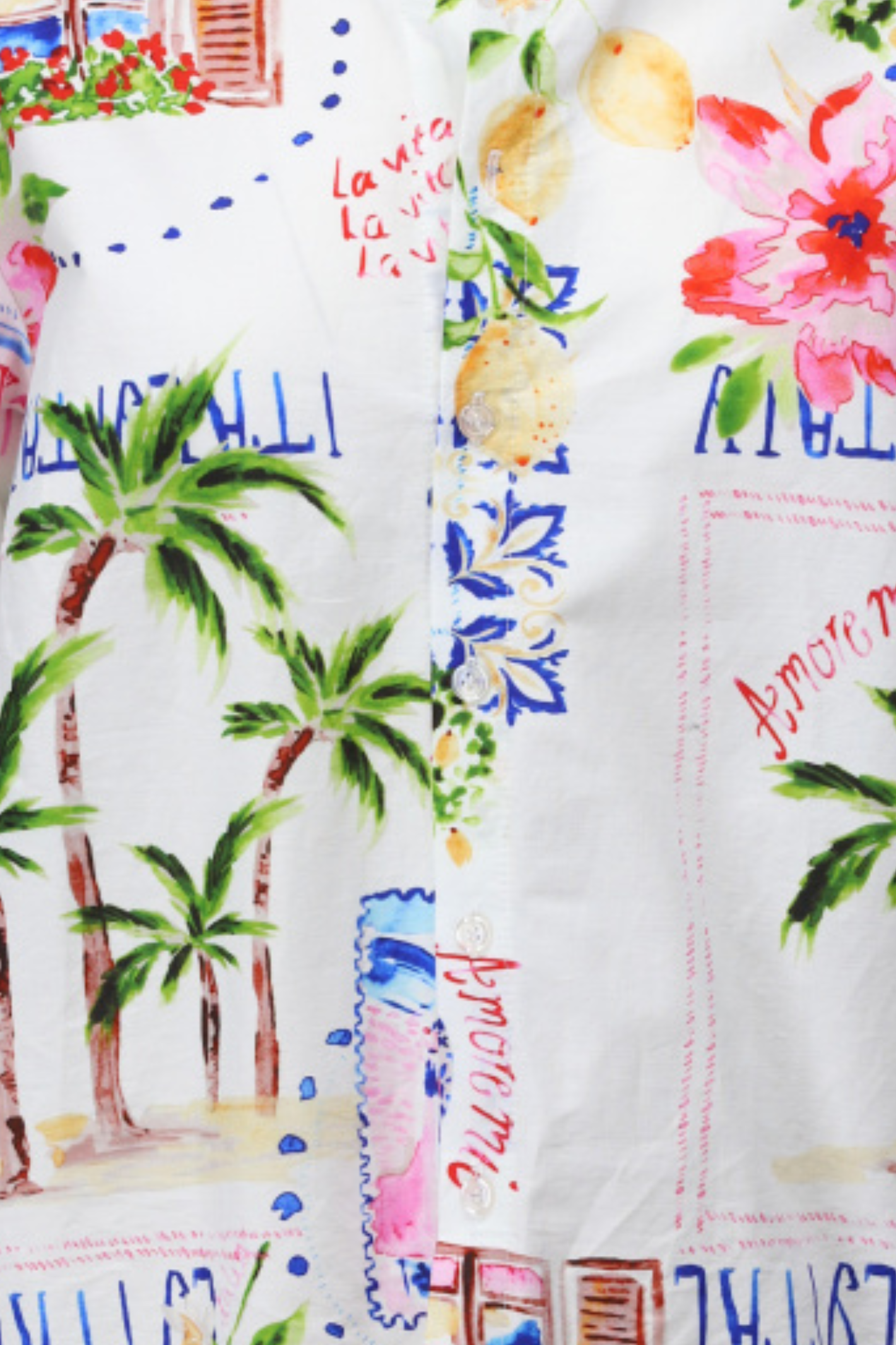 Close-up of a fabric with tropical-themed print featuring palm trees, flowers, and text.