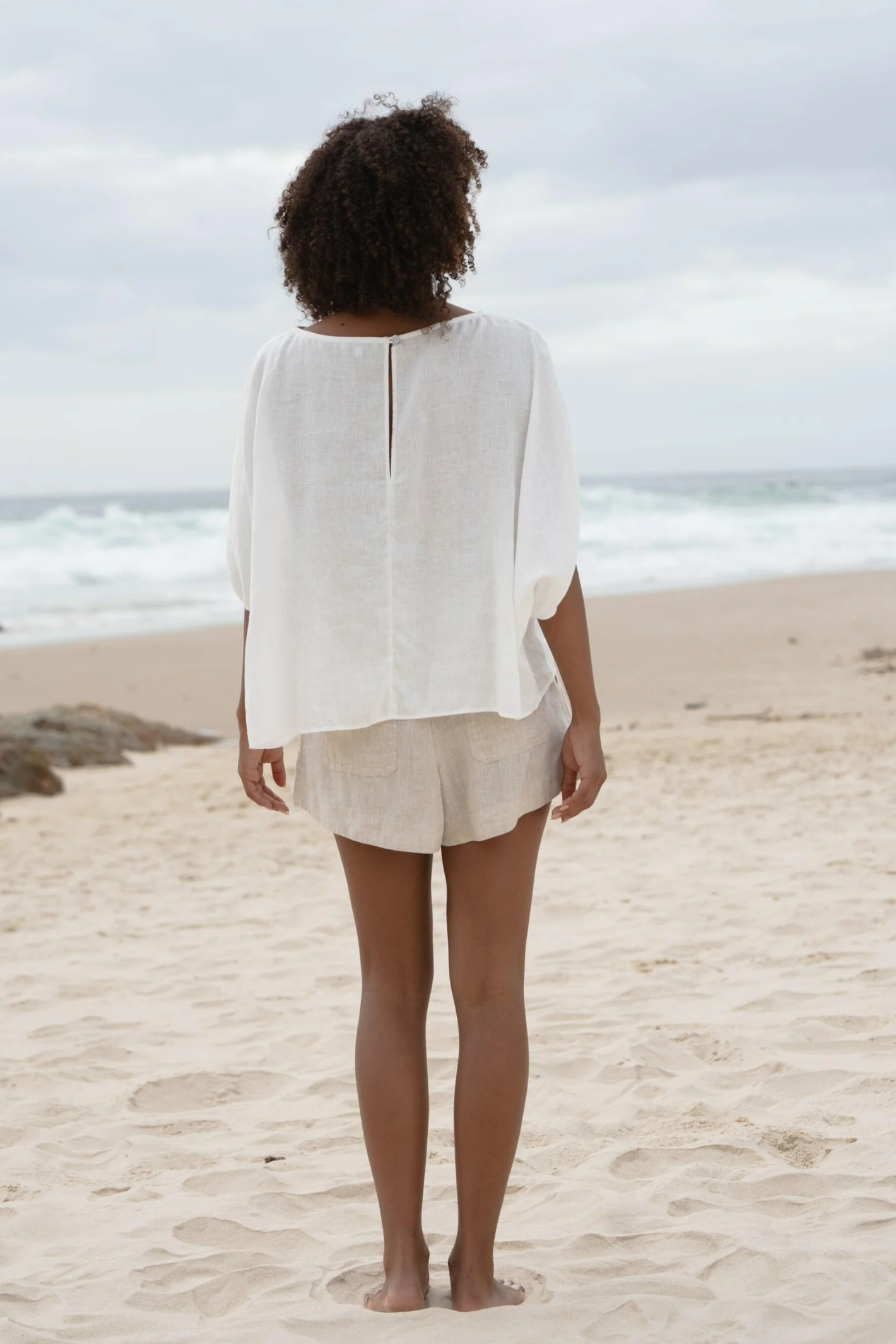 Woman on beach wearing Lilly Pilly LPW23-T001 Tina Linen Top Ivory by Lilly Pilly Shop Lilly Pilly at Dotique