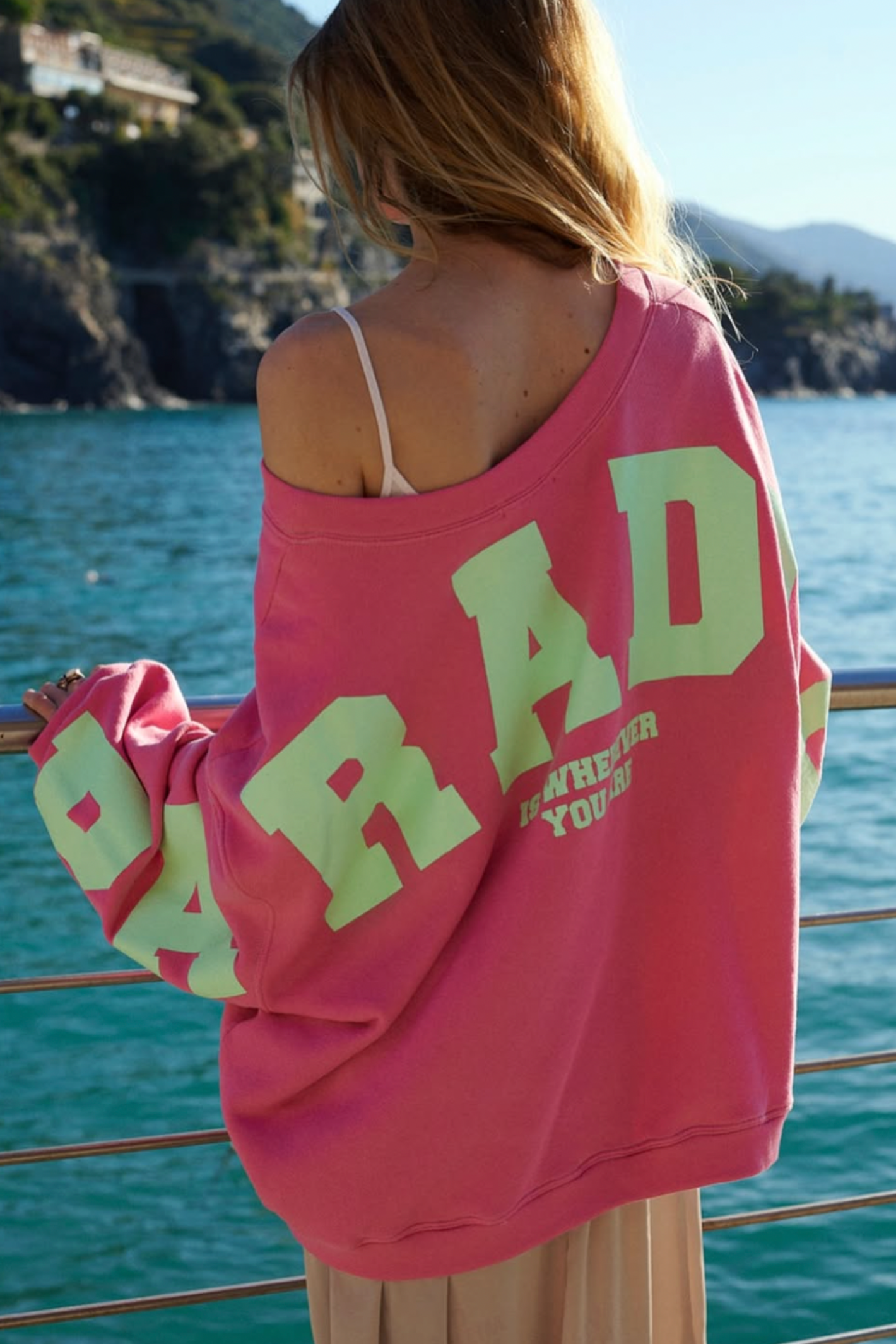 Woman wearing a pink Liv Bergen Sky Paradise Sweater – Lipstick with bold print, shop Liv Bergen at Dotique by the water.