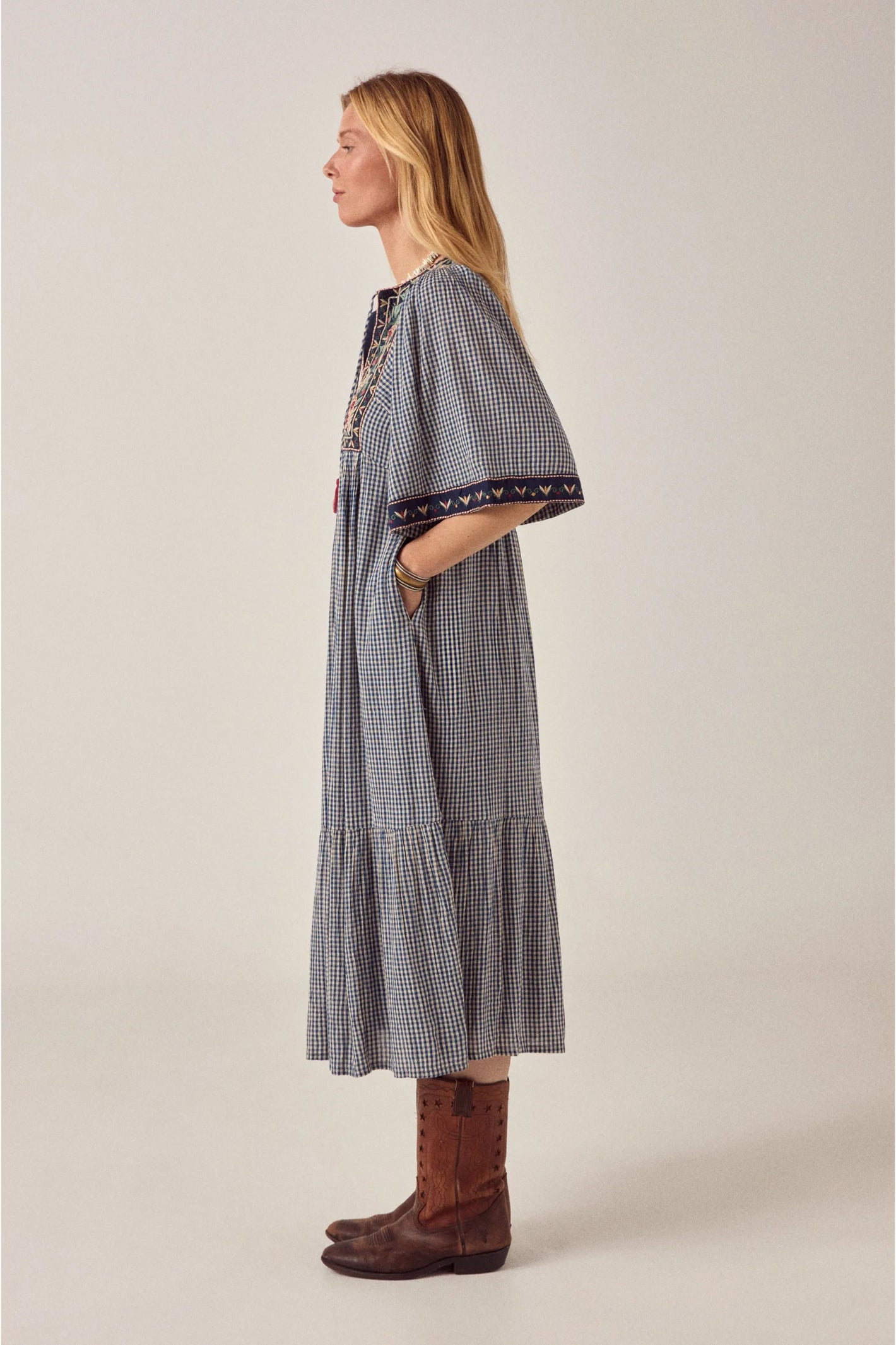Side profile of model wearing Maison Hotel Augusta Dress Bleu Picnic with embroidery and check pattern Shop Maison Hotel at Dotique
