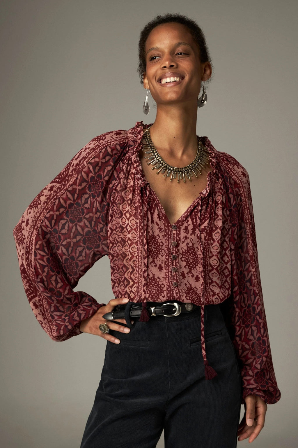 Shop the Maison Hotel Hannah Blouse in Wine at Dotique. A printed blouse with a ruffled neckline, tassel ties and voluminous sleeves.