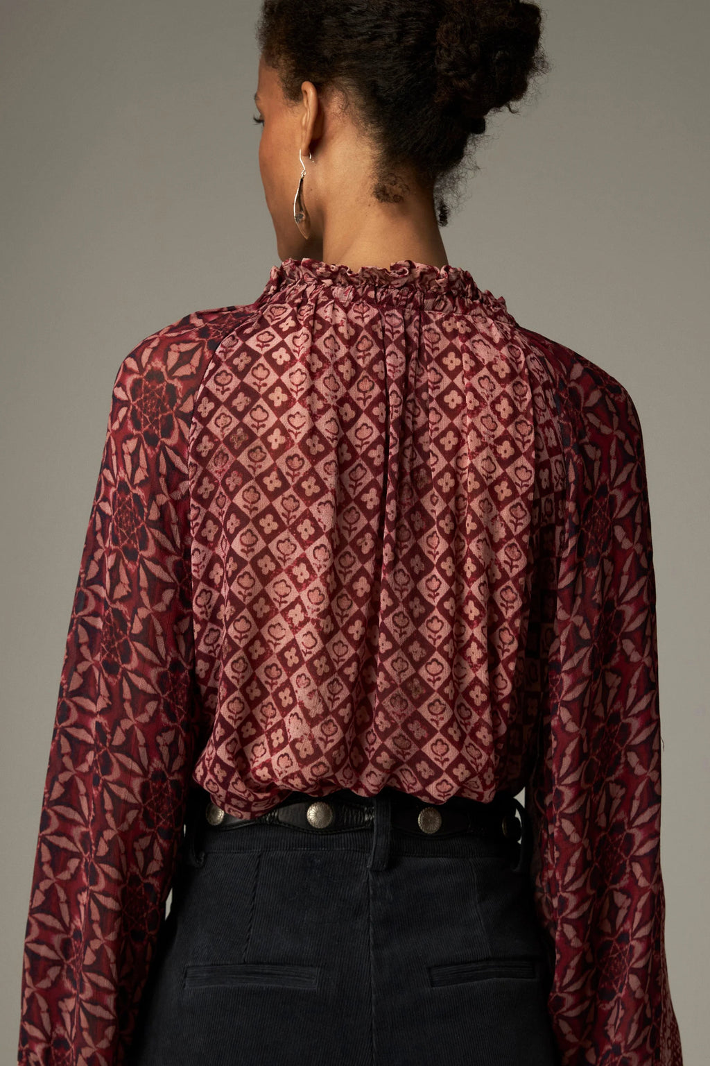 Shop the Maison Hotel Hannah Blouse in Wine at Dotique. A printed blouse with a ruffled neckline, tassel ties and voluminous sleeves.