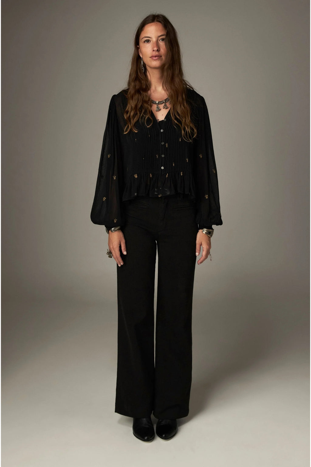 Shop the Maison Hotel Catherine Blouse in Blackout at Dotique. An embroidered black blouse with a cropped shape, ruffled hem and mother-of-pearl buttons.
