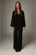 Shop the Maison Hotel Catherine Blouse in Blackout at Dotique. An embroidered black blouse with a cropped shape, ruffled hem and mother-of-pearl buttons.