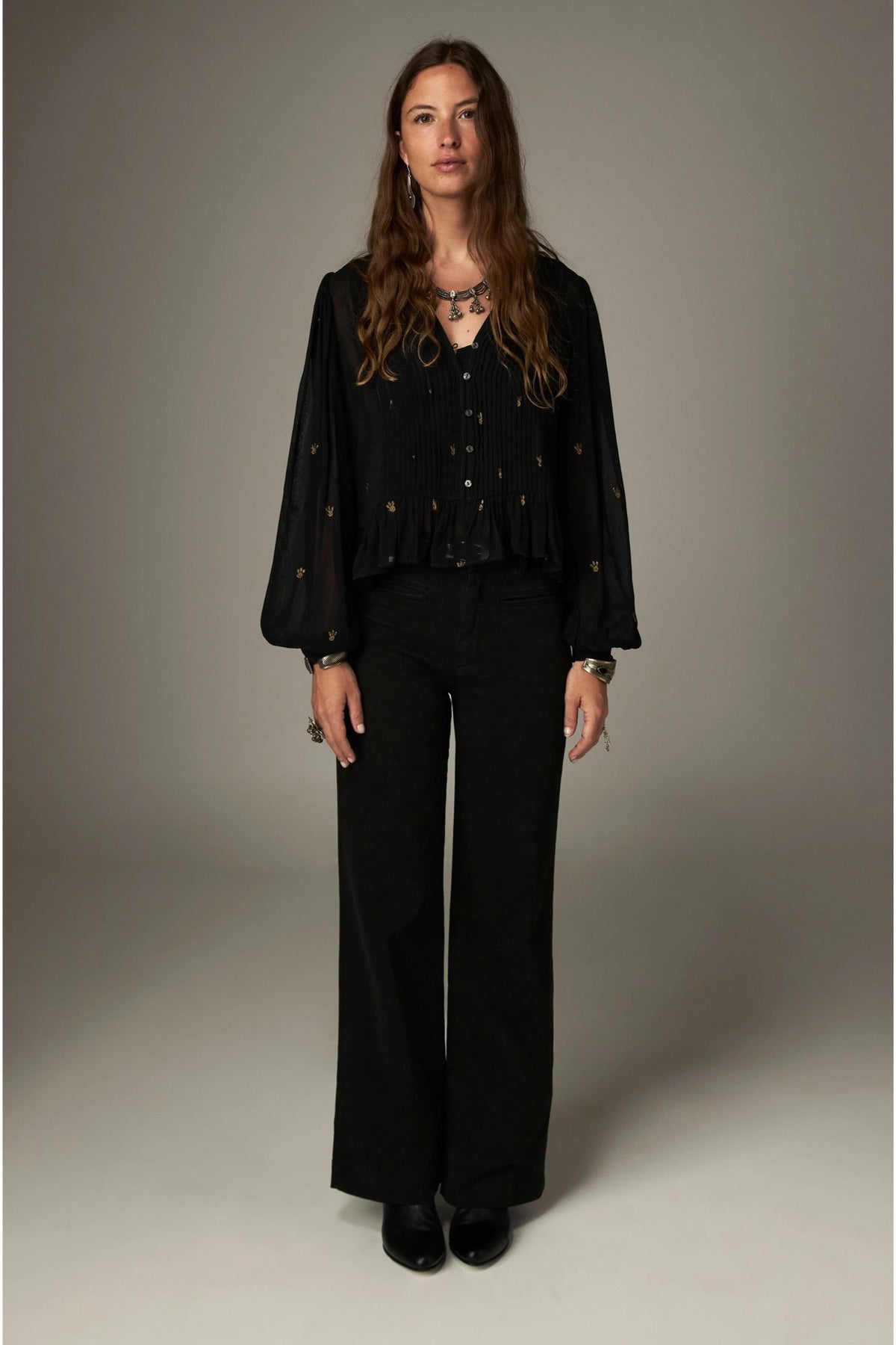 Shop the Maison Hotel Catherine Blouse in Blackout at Dotique. An embroidered black blouse with a cropped shape, ruffled hem and mother-of-pearl buttons.