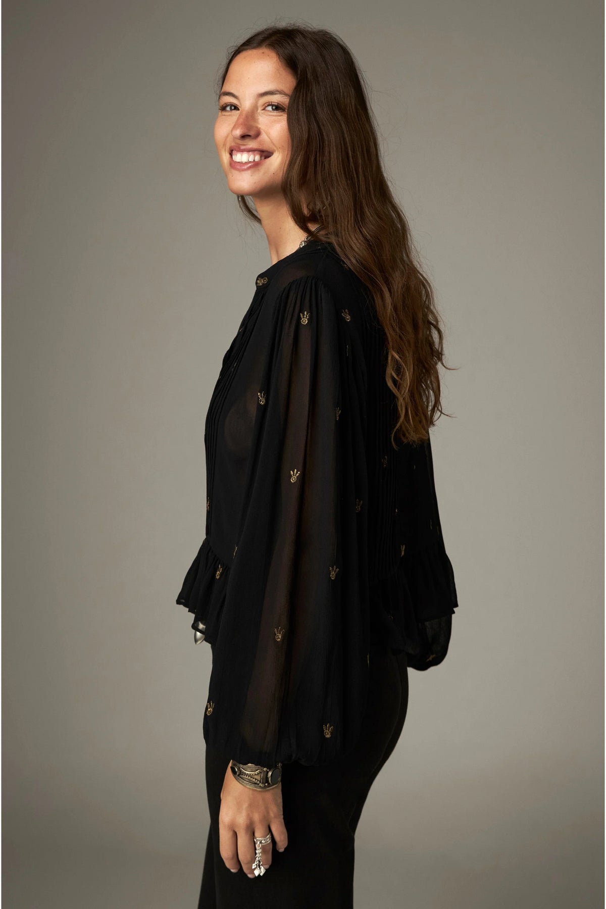 Shop the Maison Hotel Catherine Blouse in Blackout at Dotique. An embroidered black blouse with a cropped shape, ruffled hem and mother-of-pearl buttons.