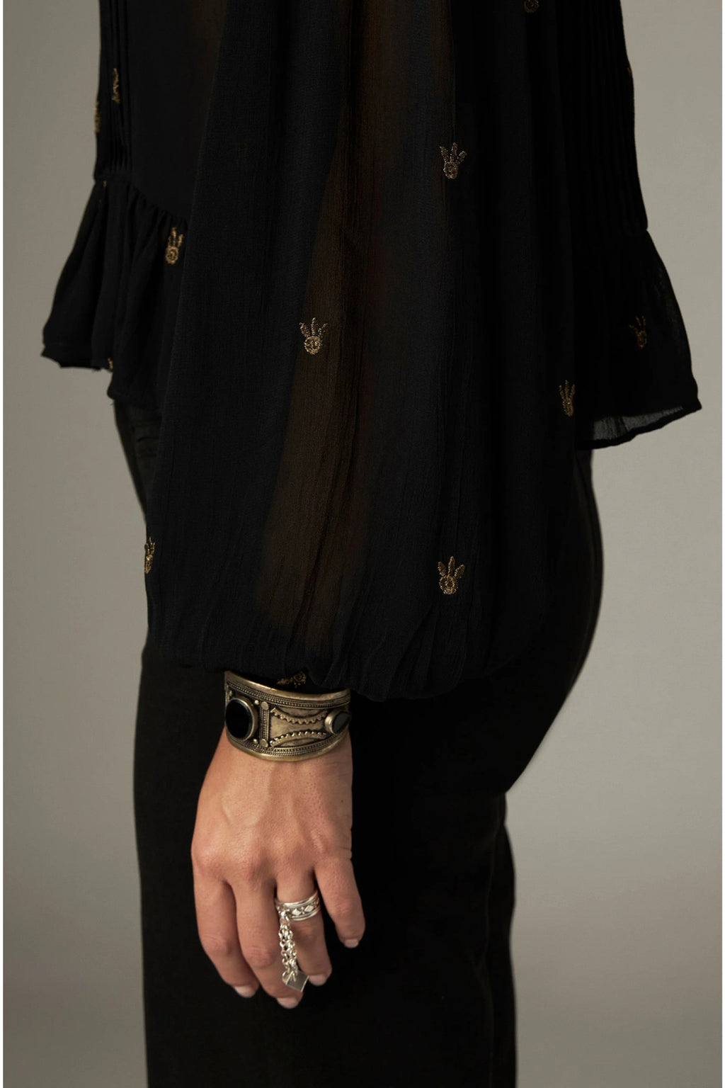 Shop the Maison Hotel Catherine Blouse in Blackout at Dotique. An embroidered black blouse with a cropped shape, ruffled hem and mother-of-pearl buttons.