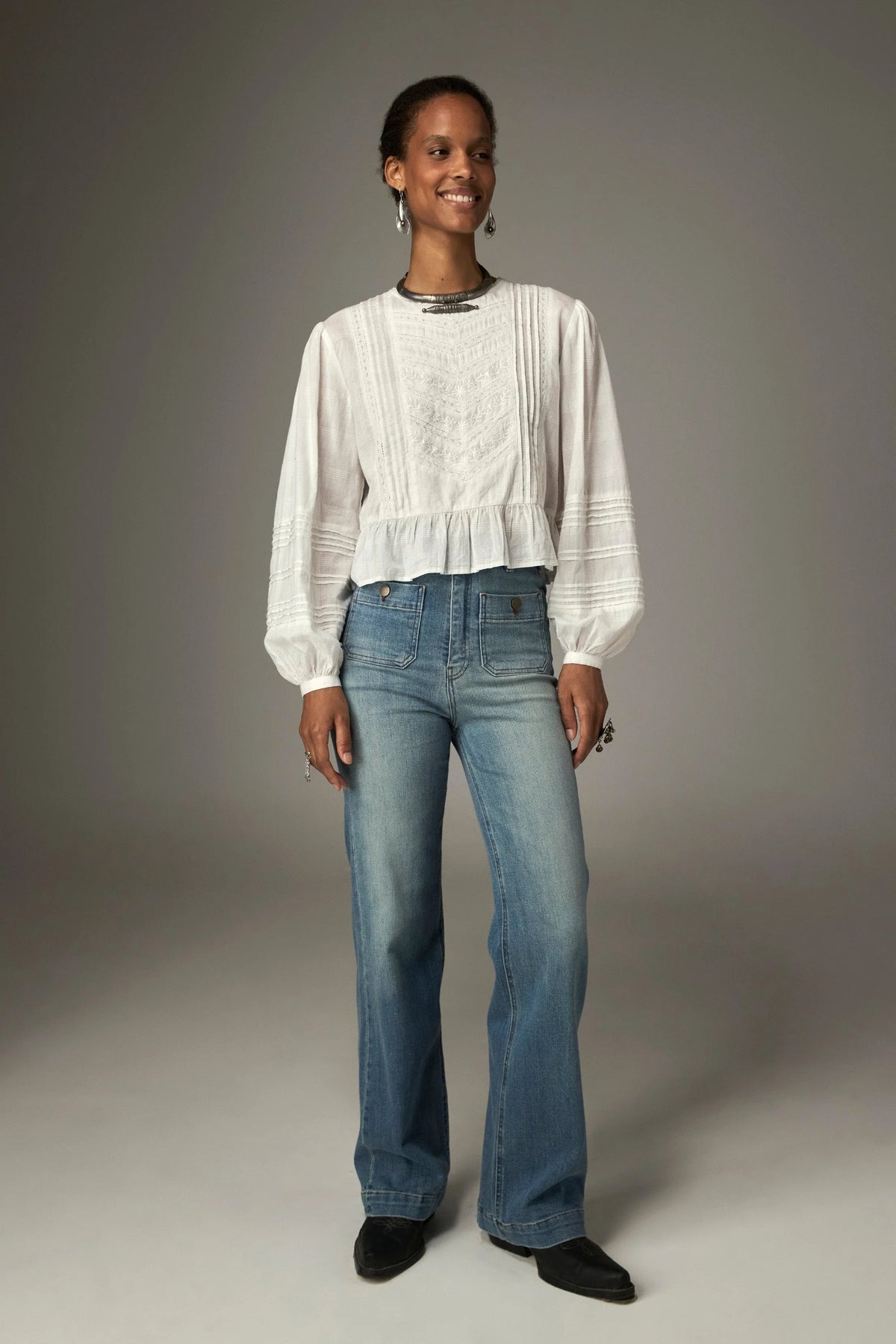 Shop the Maison Hotel Mildred Blouse in Bone at Dotique. A cropped cotton blouse with pintuck detailing, lace-trim neckline and a pretty ruffled hem.