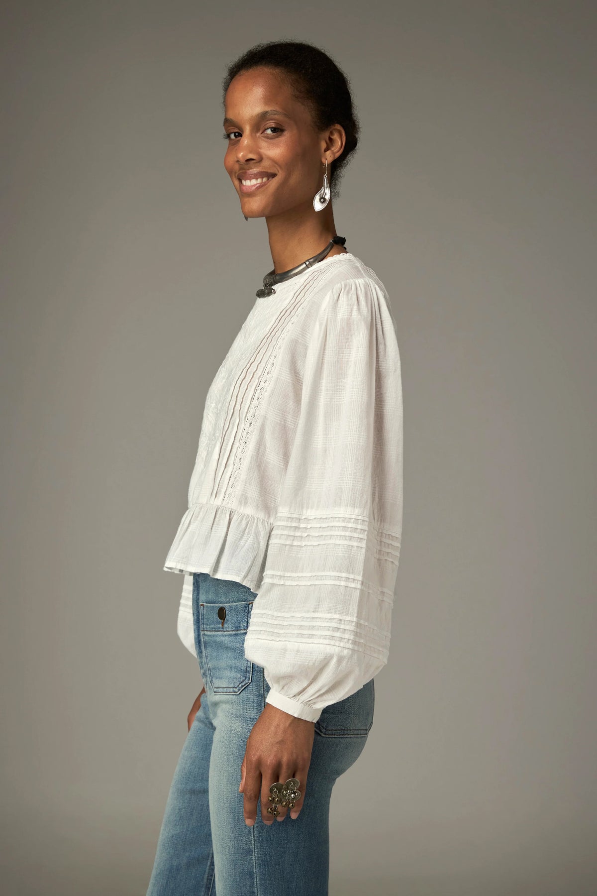 Shop the Maison Hotel Mildred Blouse in Bone at Dotique. A cropped cotton blouse with pintuck detailing, lace-trim neckline and a pretty ruffled hem.