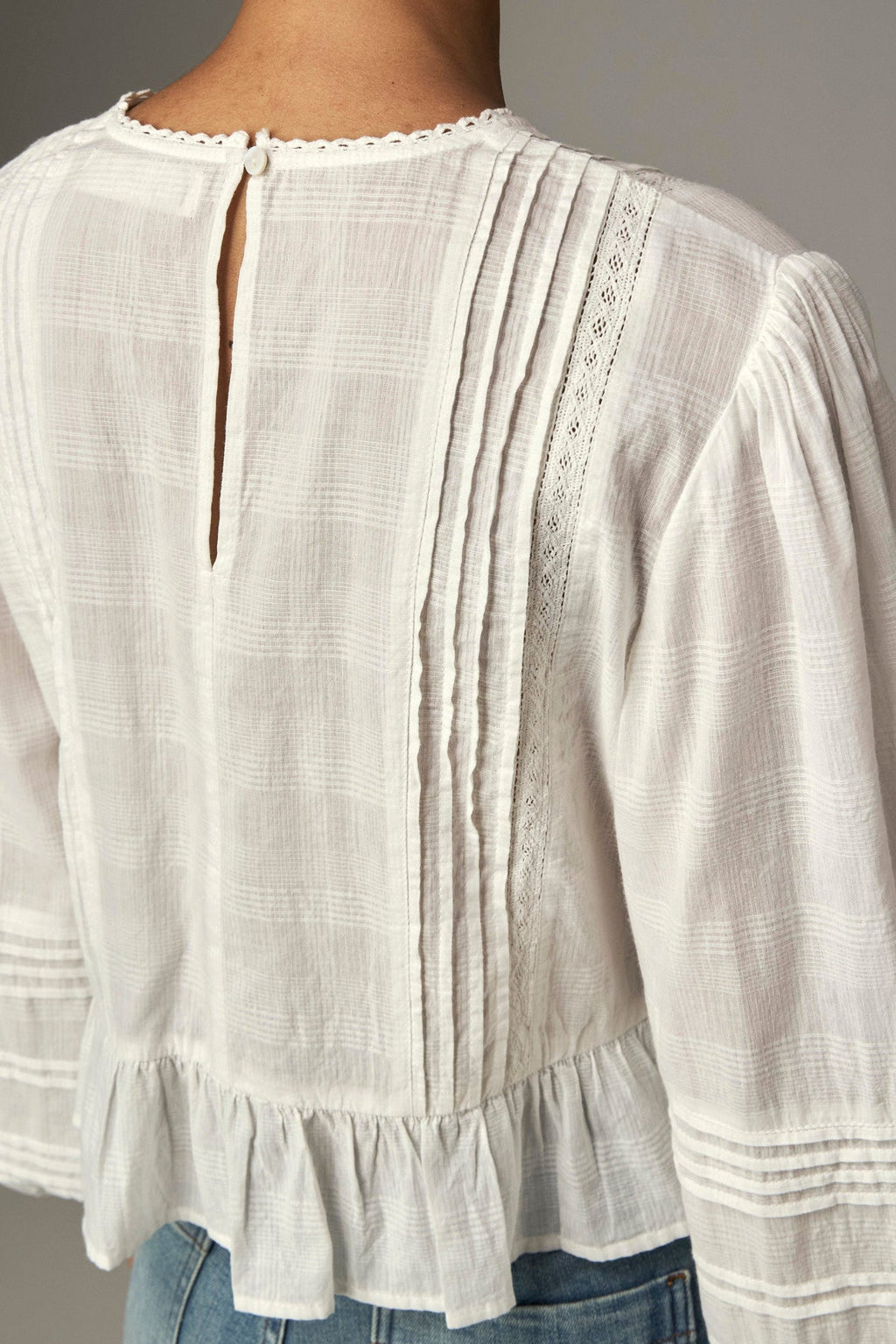 Shop the Maison Hotel Mildred Blouse in Bone at Dotique. A cropped cotton blouse with pintuck detailing, lace-trim neckline and a pretty ruffled hem.